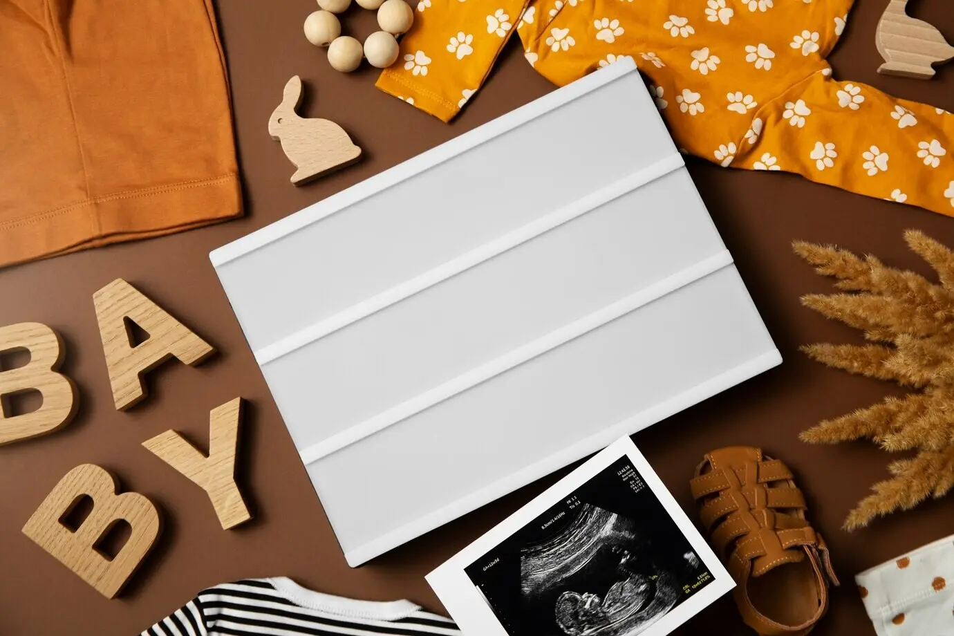 Schwangerschaftsankündigung im Flatlay mit Babyartikeln